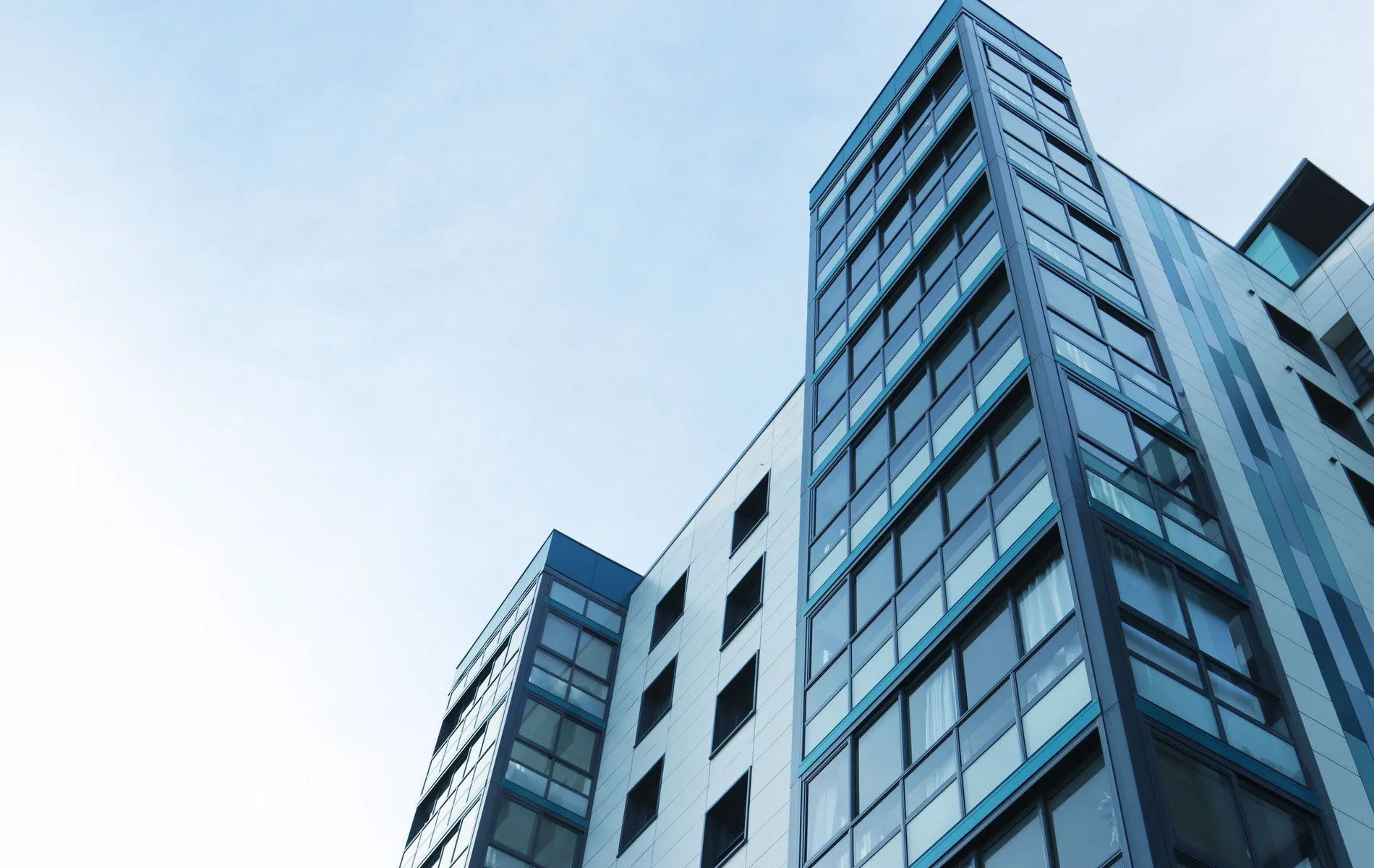 Glass and steel tower against a pale sky