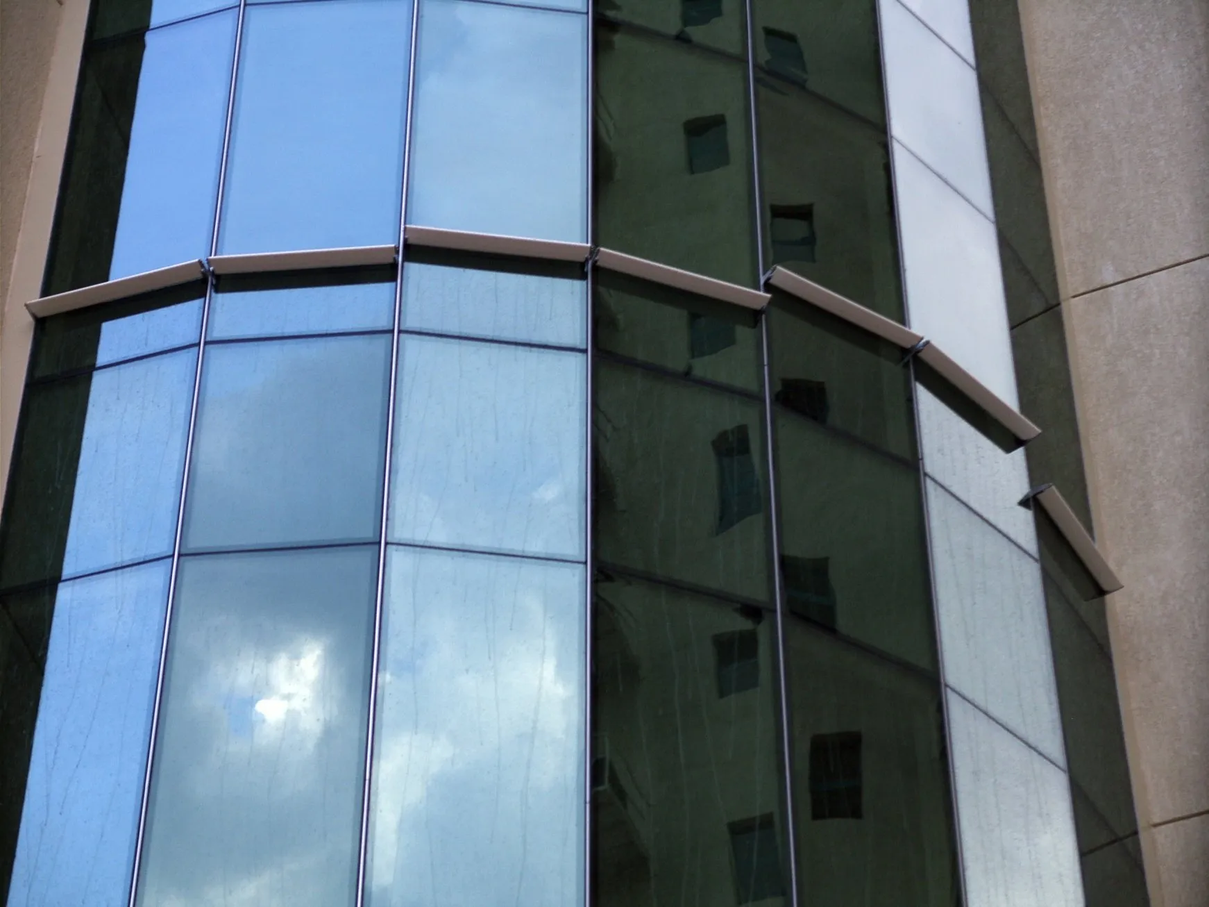 Curved glass office façade in Kuwait City cleaned by an integrated iku® Windows system